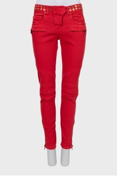 Красные джинсы декорированные люверсом