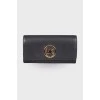Чорний гаманець із золотистим лого бренду